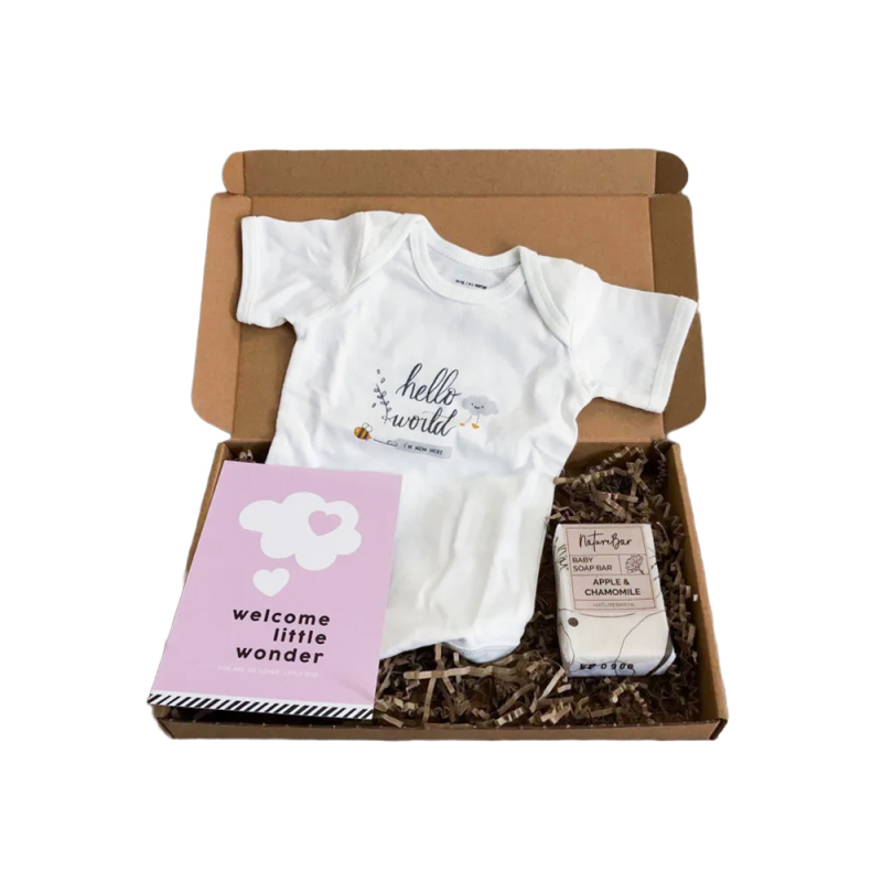 Brievenbuspakketje met rompertje, zeep voor de baby en roze kaart.